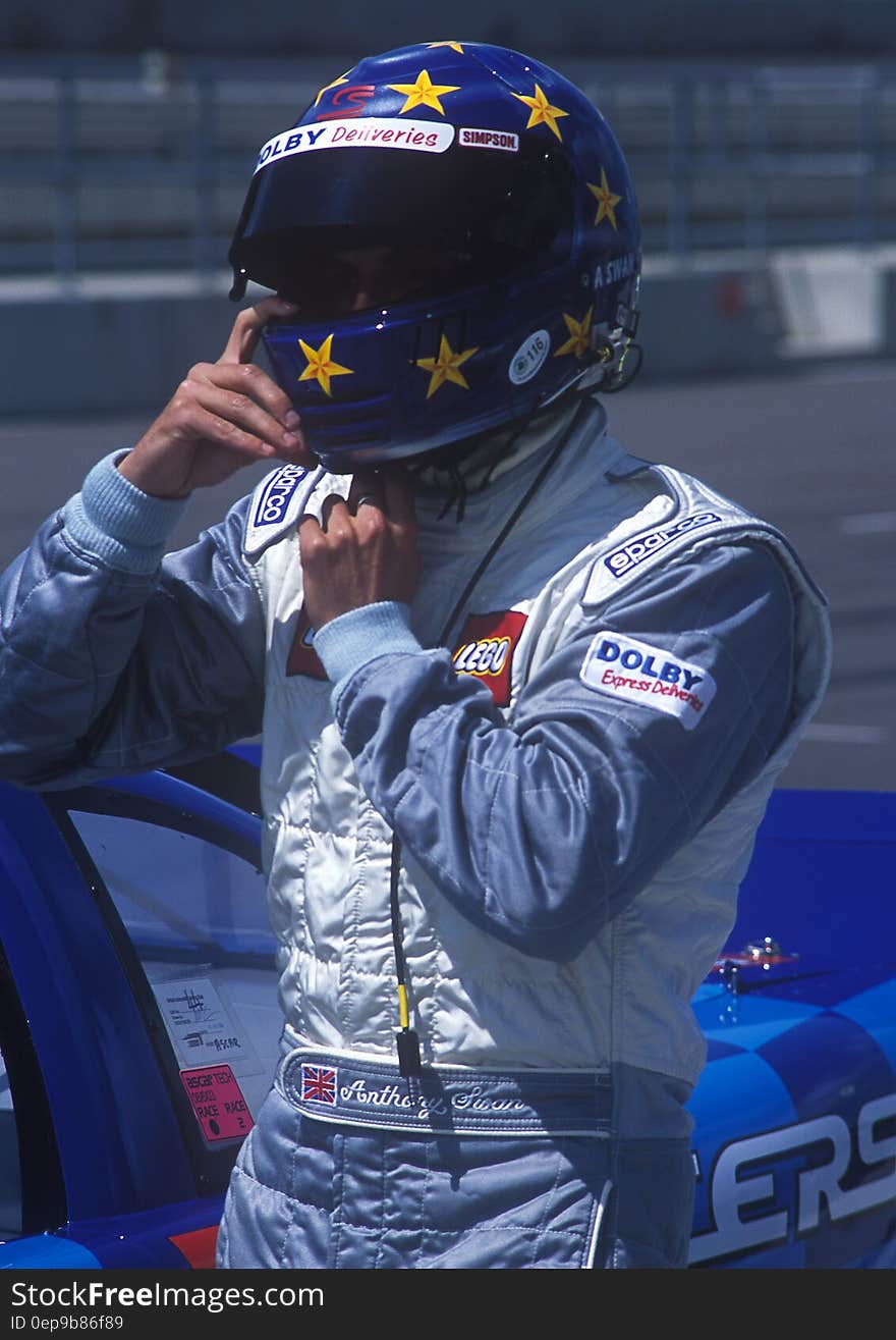 Man in Blue and and White Racer Suit Wearing His Blue and Yellow Star Full Face Helmet