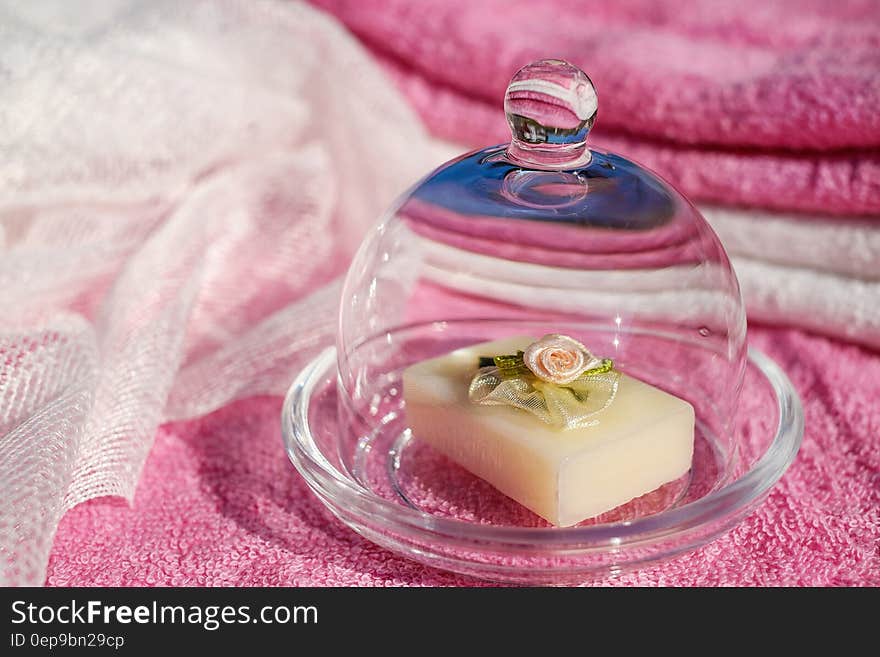 Purple and white towels and piece of soap with floral decoration in closed glass soap dish ready for relaxing bath. Purple and white towels and piece of soap with floral decoration in closed glass soap dish ready for relaxing bath.