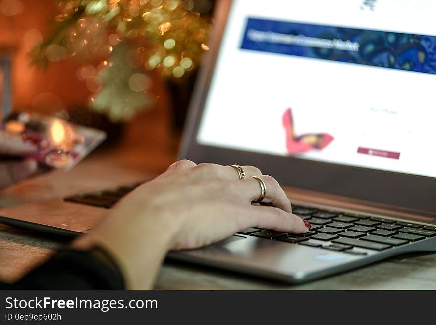 Right Hand With Gold Ring on Black and Grey Laptop Computer