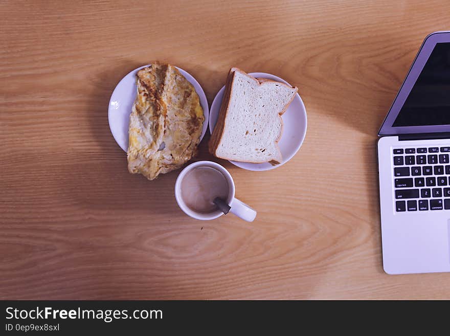 White Ceramic Mug Beside Bread on White Ceramic Saucer