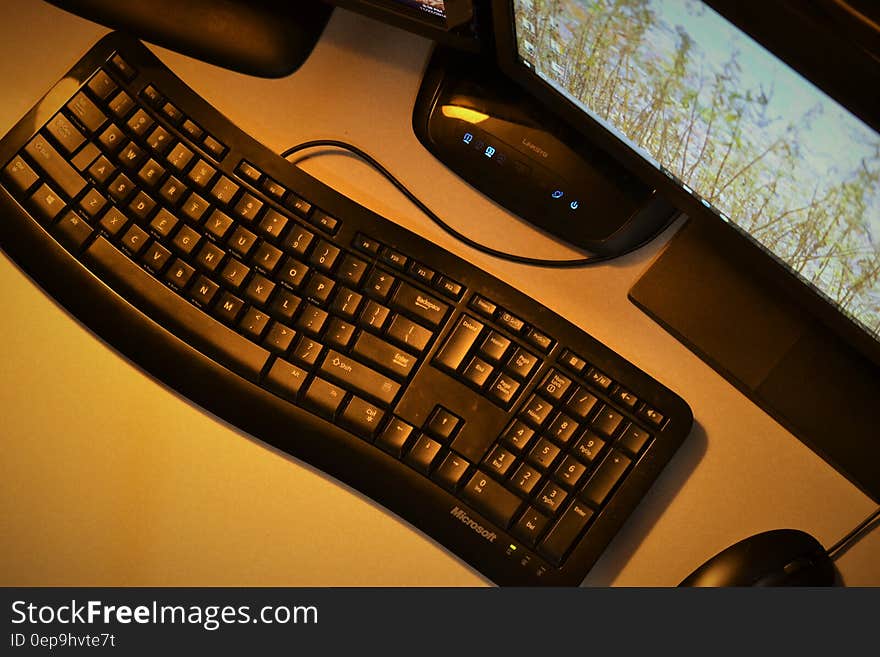 Desktop computer with keyboard, mouse, amplifier and wide screen with map details displayed, yellow background.