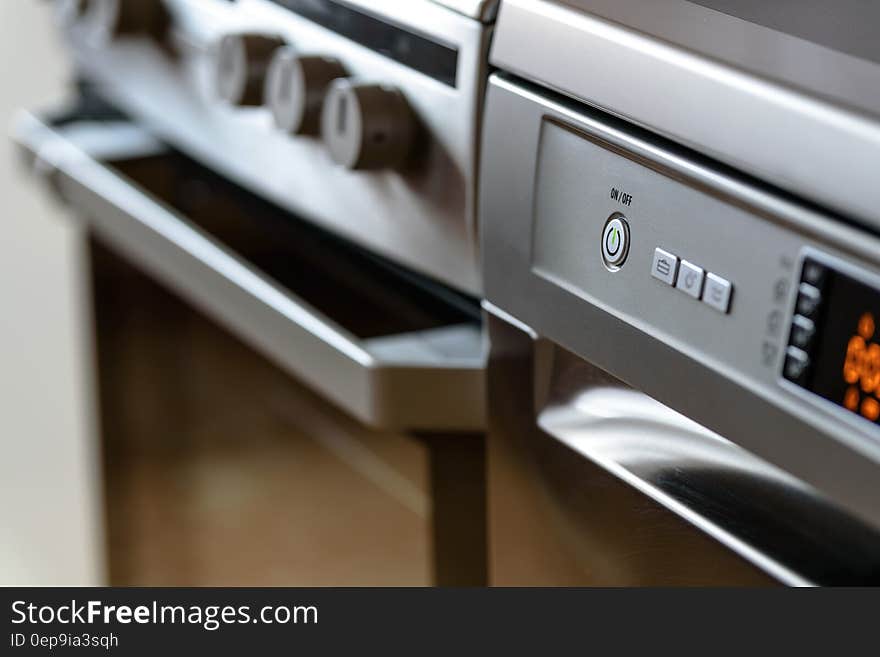 Closeup of modern kitchen cooker and dishwasher appliance with electronic display.