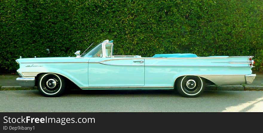 Classic convertible car parked on street.