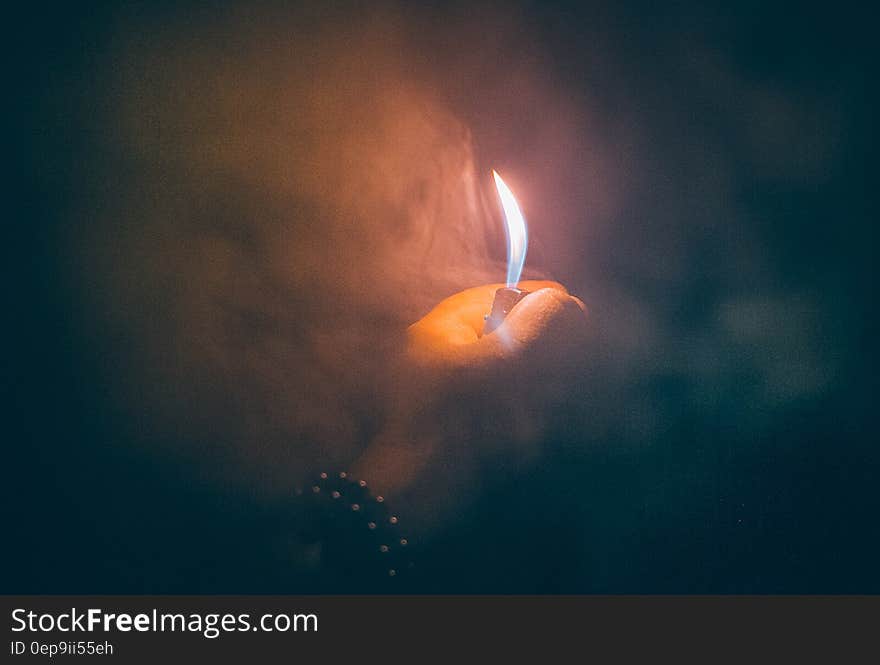 Close up of hand holding small lighter in smoke. Close up of hand holding small lighter in smoke.