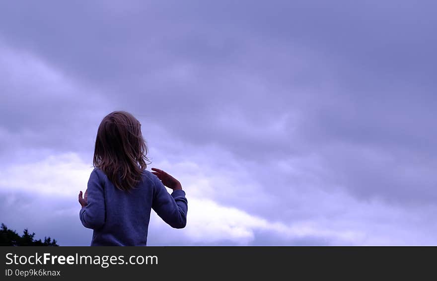 Woman in Blue Sweater Facing in Blue Clear Sky