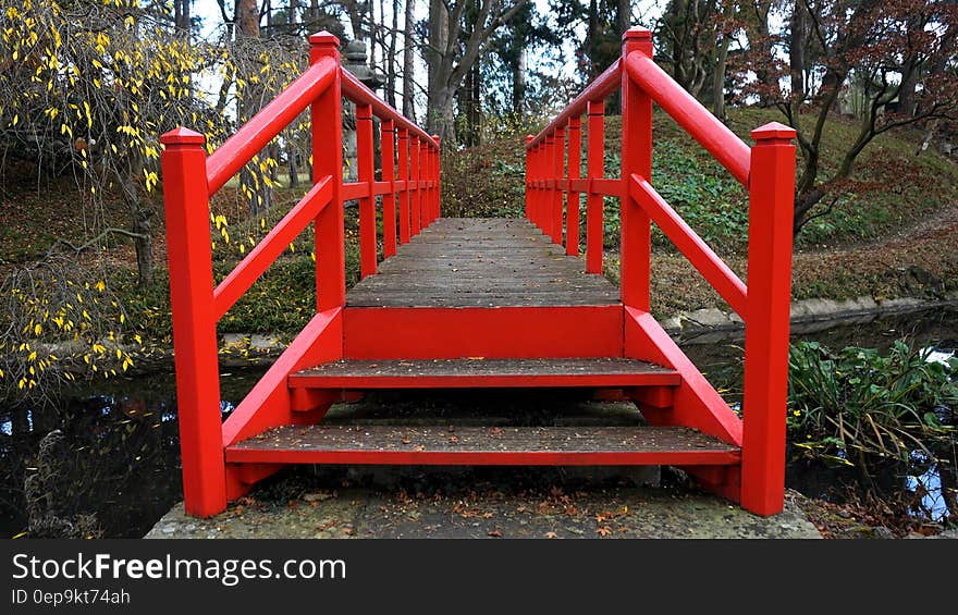 Red wooden bridge in sunny garden woods. Red wooden bridge in sunny garden woods.