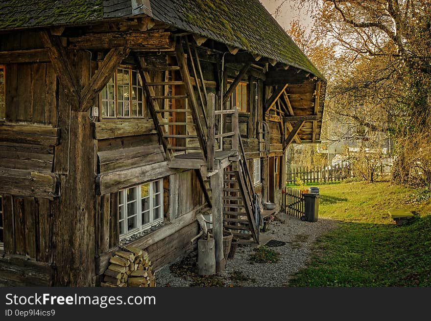 Exterior of rustic wooden log farm house in green field on sunny day. Exterior of rustic wooden log farm house in green field on sunny day.