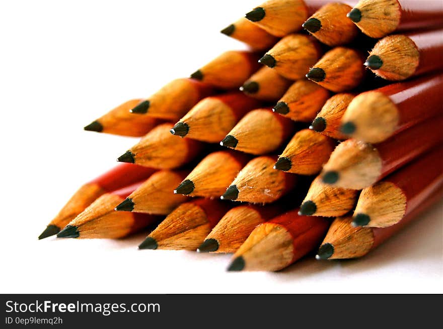 Pile of red wooden pencils with sharpened tips on white. Pile of red wooden pencils with sharpened tips on white.