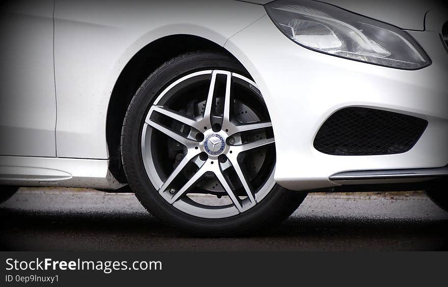 Close up of front right fender and side of white luxury car.