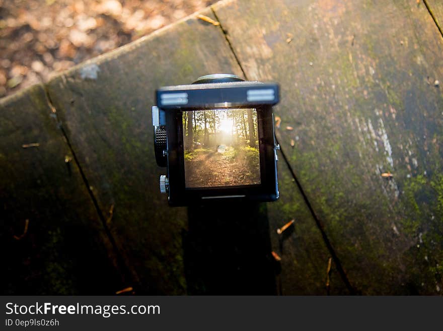 Black Camera on Brown Wooden Table