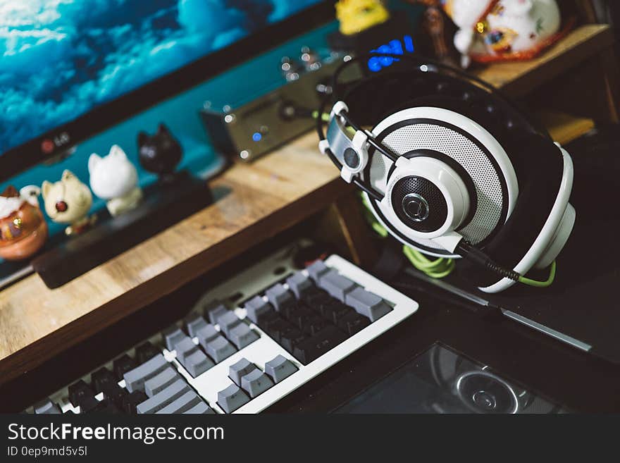 Black and White Headset Next to White Black and Gray Computer Keyboard