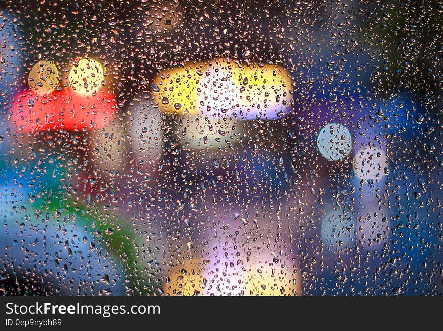 A surface with rain drops on it with defocused lights behind it. A surface with rain drops on it with defocused lights behind it.