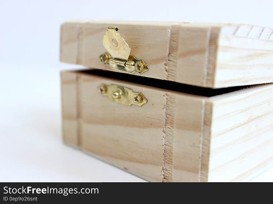 An unfinished antique wooden box with a latch.