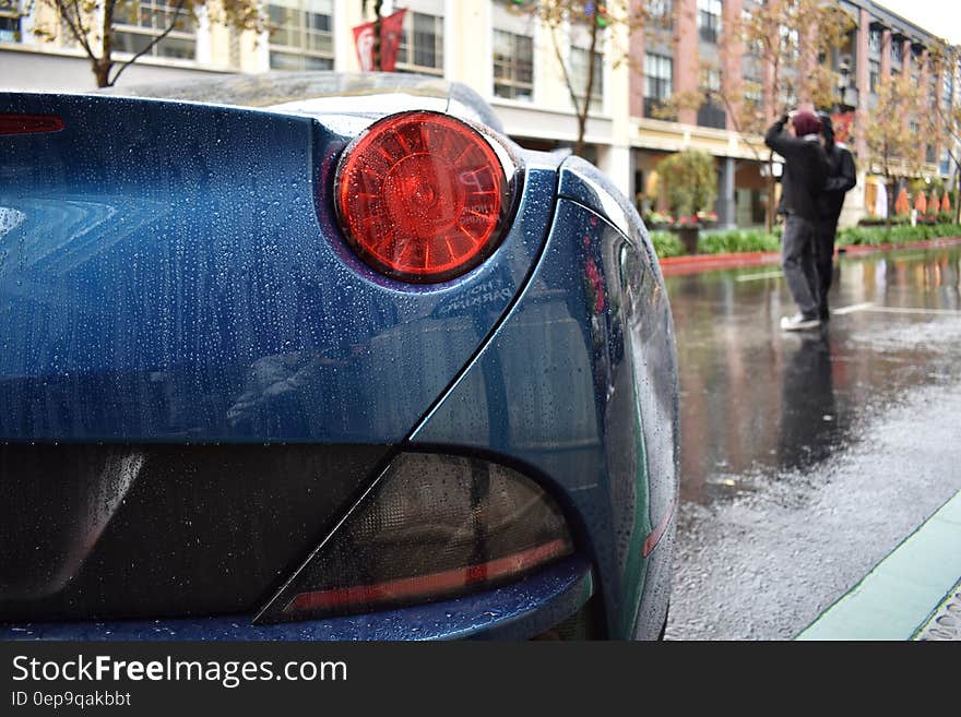 Taillight of blue sports car on streets in rain. Taillight of blue sports car on streets in rain.