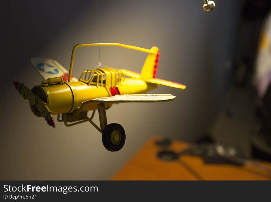 Yellow single seat propeller driven model aeroplane with undercarriage down and blue and yellow star on the wings. Yellow single seat propeller driven model aeroplane with undercarriage down and blue and yellow star on the wings.