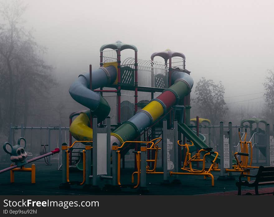 Colorful slide and rides in playground on foggy day. Colorful slide and rides in playground on foggy day.