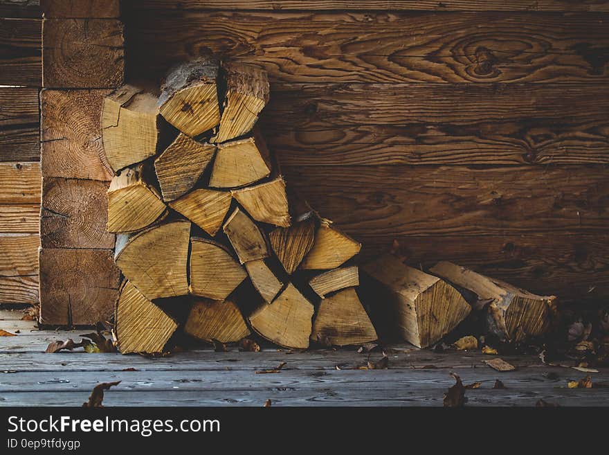 Stack of firewood against wooden wall on boards. Stack of firewood against wooden wall on boards.