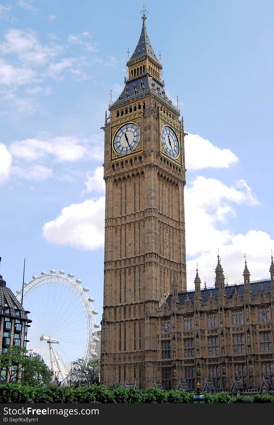 Big Ben clock tower and Parliament Building with London Eye against blue skies. Big Ben clock tower and Parliament Building with London Eye against blue skies.