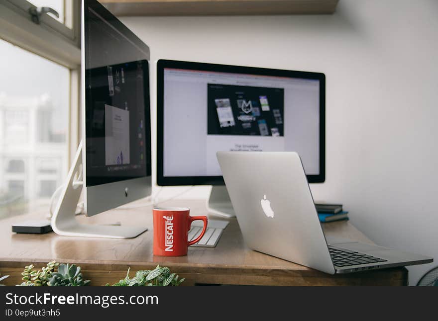 Silver Macbook on Top of Brown Wooden Table