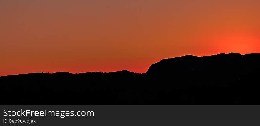 Black Mountain Under Brown Sky during Sunset