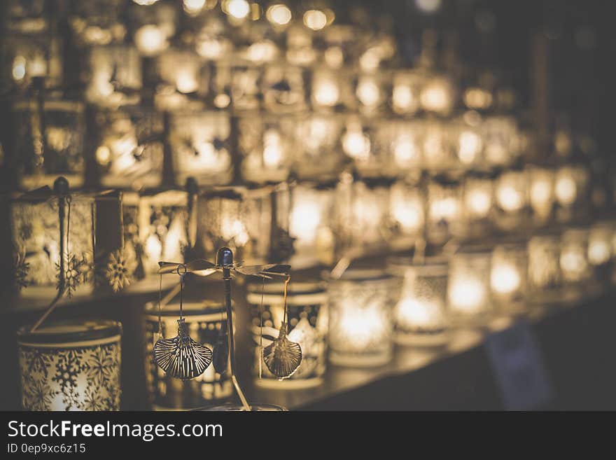 Candles burning inside holders on shelves. Candles burning inside holders on shelves.