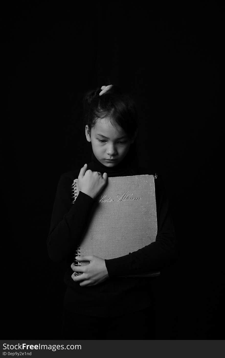 Portrait of young girl holding schoolbook in black and white. Portrait of young girl holding schoolbook in black and white.