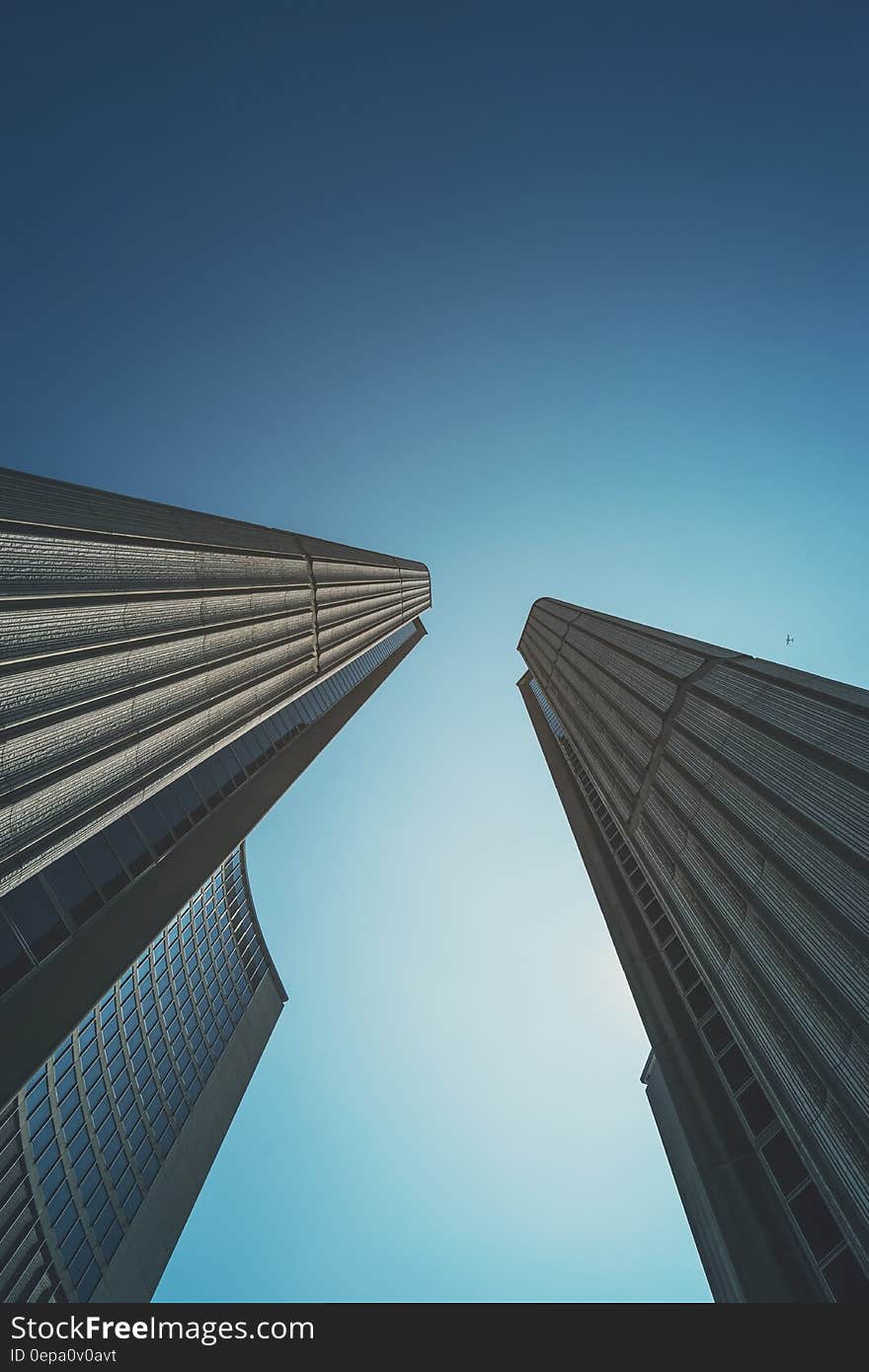 Modern skyscrapers against blue skies on sunny day.