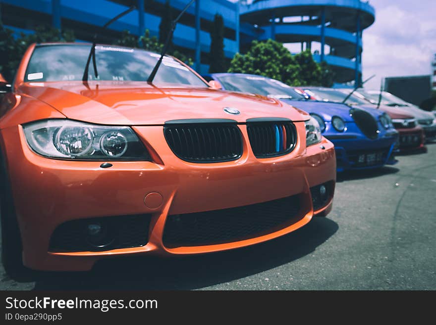 Orange Bmw Car Beside Blue Bugatti Car