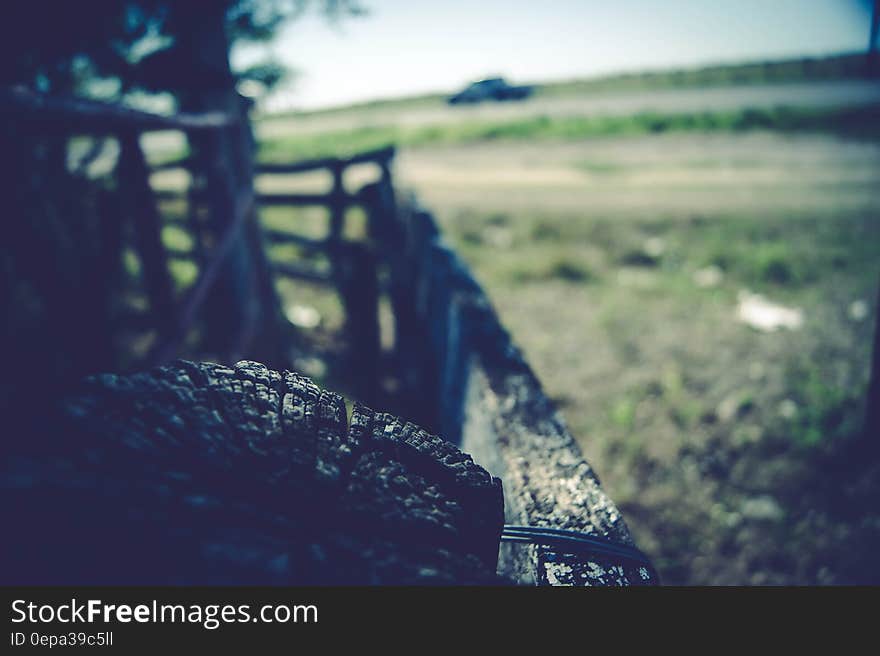 Mud covered off-road vehicle parked next to fence in countryside with field in background. Mud covered off-road vehicle parked next to fence in countryside with field in background.