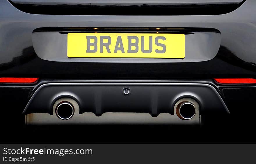 Yellow Brabus automotive sign on back of black sports car. Yellow Brabus automotive sign on back of black sports car.