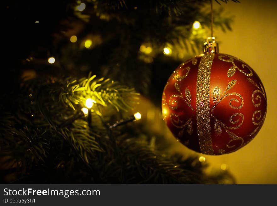 Red and gold Christmas ornament on tree with lights. Red and gold Christmas ornament on tree with lights.