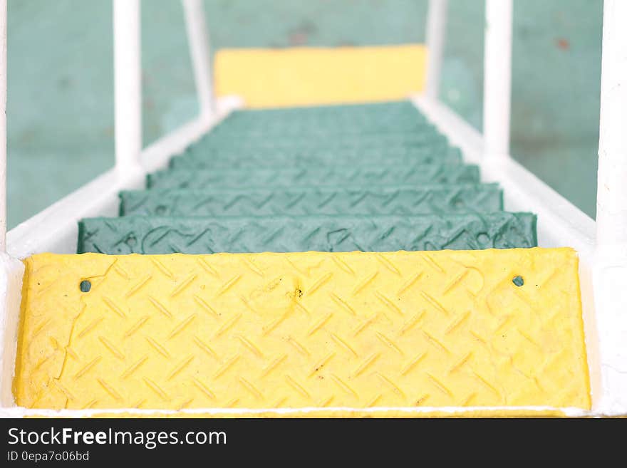 Flight of green metal stairs, only first and last yellow. Flight of green metal stairs, only first and last yellow.