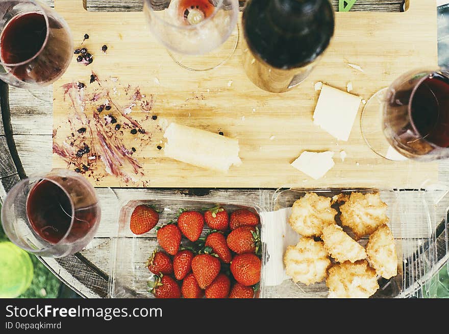 Glasses of red wine with strawberries and cookies on wooden tabletop. Glasses of red wine with strawberries and cookies on wooden tabletop.