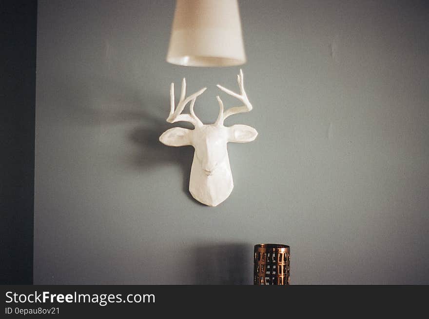 A white ceramic deer head as wall decoration.