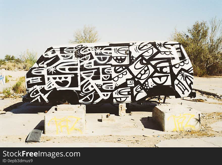 Graffiti on old van parked in desert.