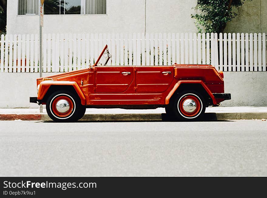 Vintage red convertible car parked on streets on sunny day. Vintage red convertible car parked on streets on sunny day.