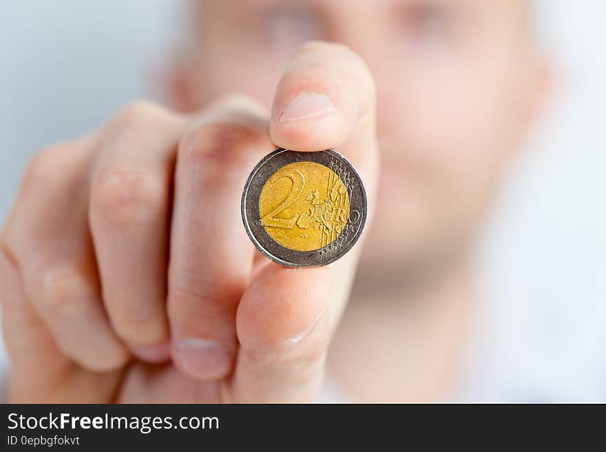 Person Holding a Gold and Silver Round Coin