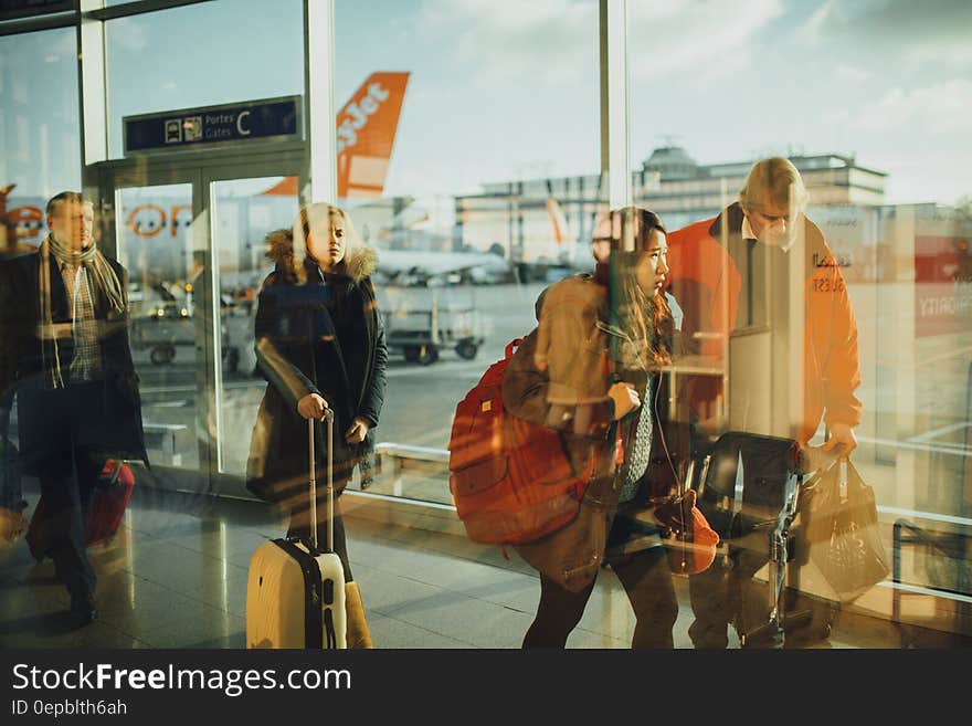 People Walking on Path Through Glass Walls at Daytime