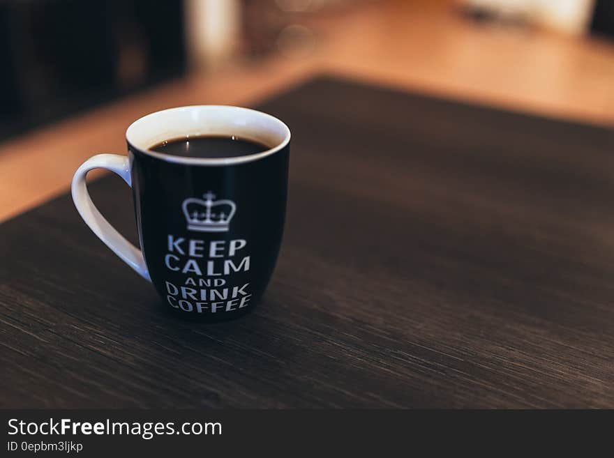 Black and White Ceramic Mug on Wooden Table