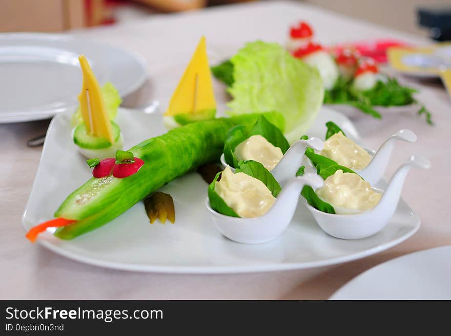 White china plate on restaurant table with colorful vegetables in fun shapes. White china plate on restaurant table with colorful vegetables in fun shapes.