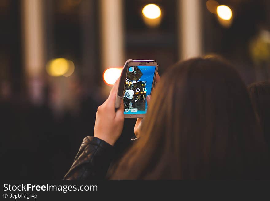 Girl using smartphone app on urban streets at night. Girl using smartphone app on urban streets at night.