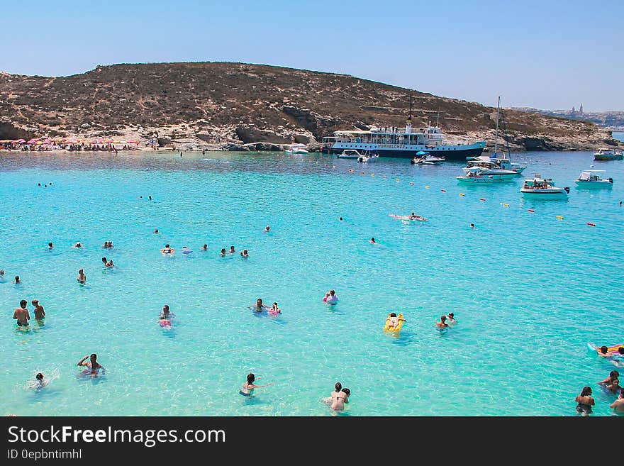 Swimmers in blue coastal waters on sunny day in Malta. Swimmers in blue coastal waters on sunny day in Malta.