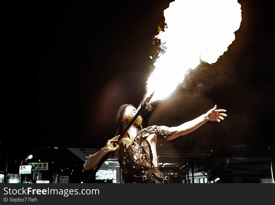 A fire breather blowing flames from his mouth.