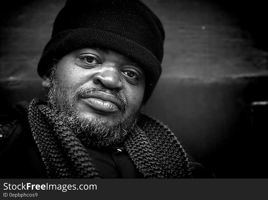 Portrait of man with beard wearing hat and scarf in black and white. Portrait of man with beard wearing hat and scarf in black and white.