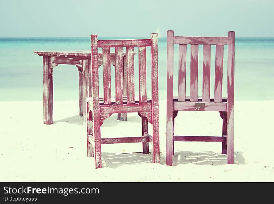 Wooden chairs and table on empty beach on sunny day. Wooden chairs and table on empty beach on sunny day.