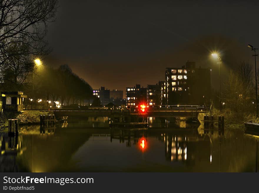 Urban lights reflecting in calm waters along waterfront. Urban lights reflecting in calm waters along waterfront.