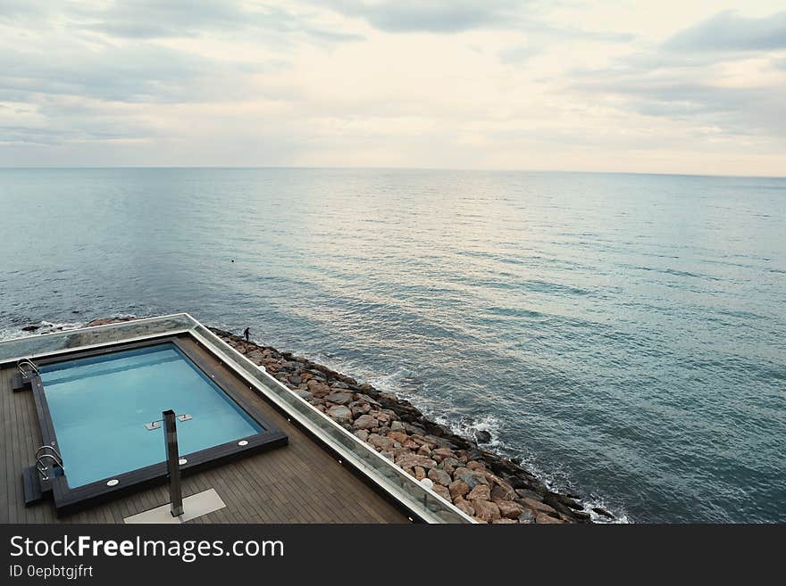 Seaside swimming pool along rocky coast on sunny day. Seaside swimming pool along rocky coast on sunny day.