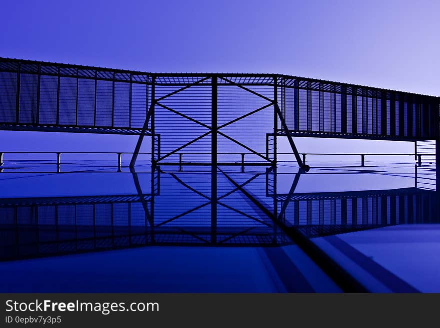 Abstract modern building facade showing underside of external staircase with blue tone.