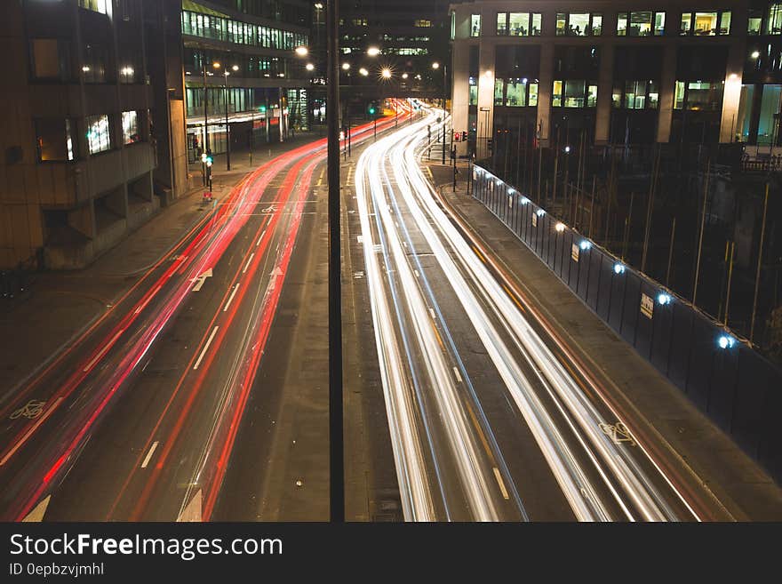 Streaks of white headlights and red taillights through city streets at night. Streaks of white headlights and red taillights through city streets at night.