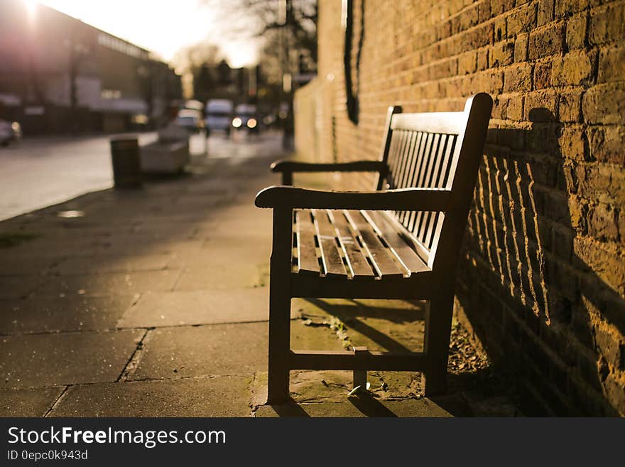 Brown Wooden Bench on the Side of the Road